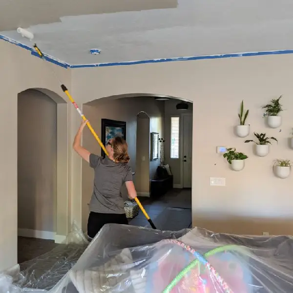 woman painting the ceiling with roller